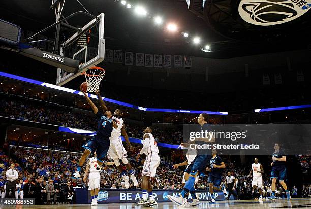 Jordan Adams of the UCLA Bruins goes to the basket as Casey Prather of the Florida Gators defends during a regional semifinal of the 2014 NCAA Men's...