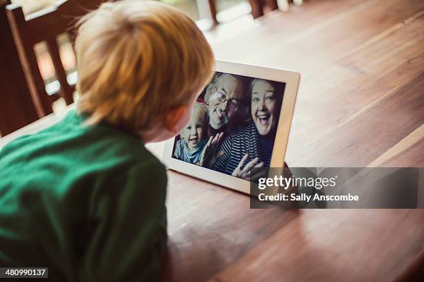 family staying connected online - wooden table kids stockfoto's en -beelden