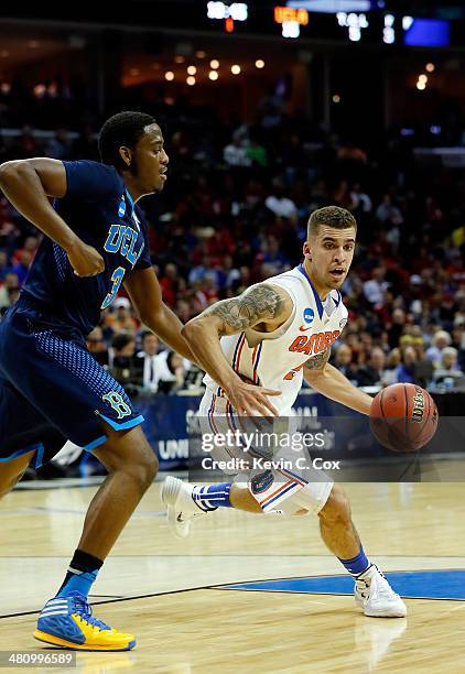 Scottie Wilbekin of the Florida Gators drives to the basket as Jordan Adams of the UCLA Bruins defends during a regional semifinal of the 2014 NCAA...