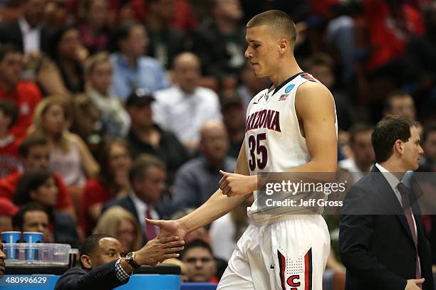 Kaleb Tarczewski of the Arizona Wildcats is taken out of the game after getting his fourth foul and gives assistant coach Damon Stoudamire a five...