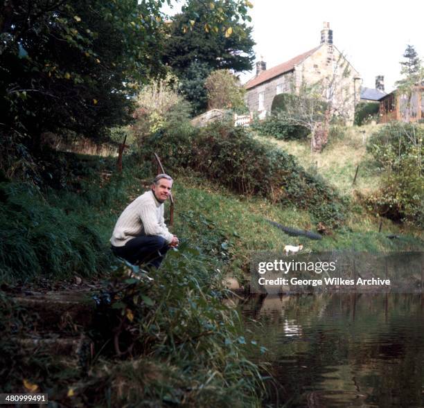 Portrait of English actor Ian Carmichael, OBE as he poses beside a river, London, England, 1975.