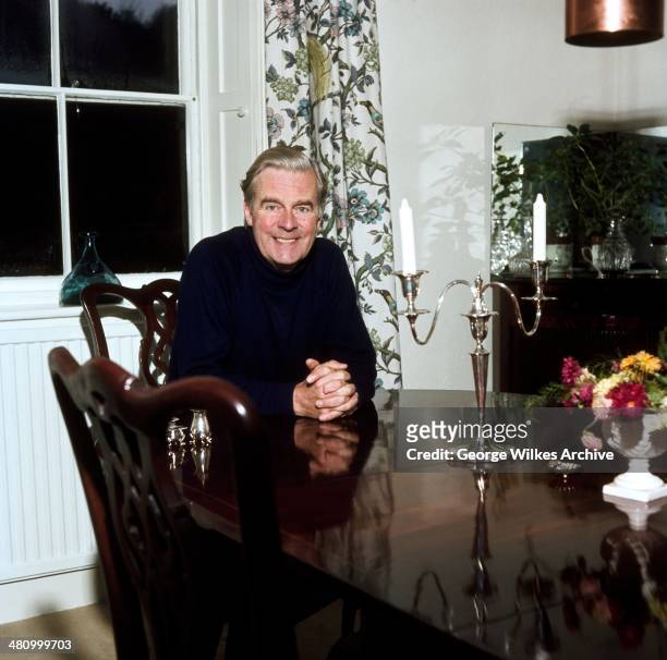 Portrait of English actor Ian Carmichael, OBE as he sits at a table, London, England, 1975.
