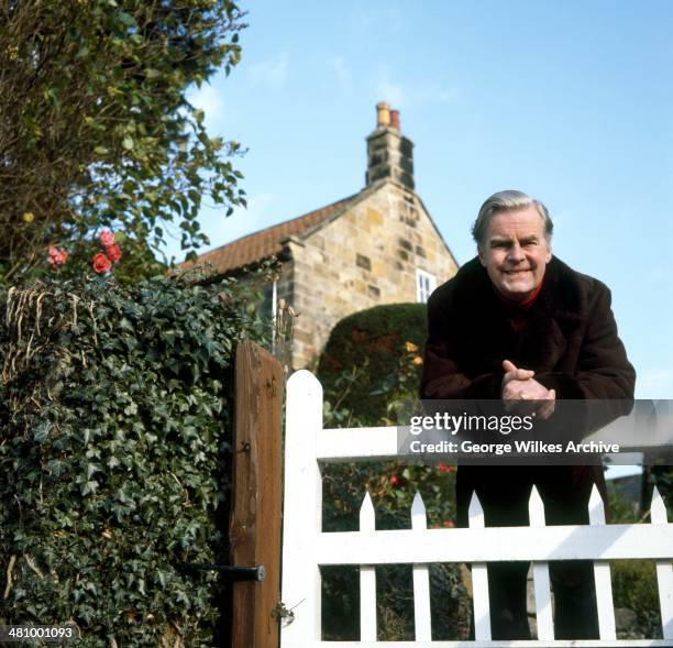 Portrait of English actor Ian Carmichael, OBE as he leans over a gate, London, England, 1975.