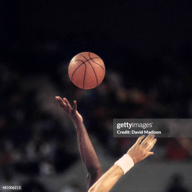 two players reaching for basketball - basketball sport stock pictures, royalty-free photos & images