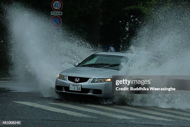 An vehicle drives among the flooded road during the heavy rain and wind delivered by typhoon Nangka on July 17, 2015 in Himeji, Japan. As Typhoon...