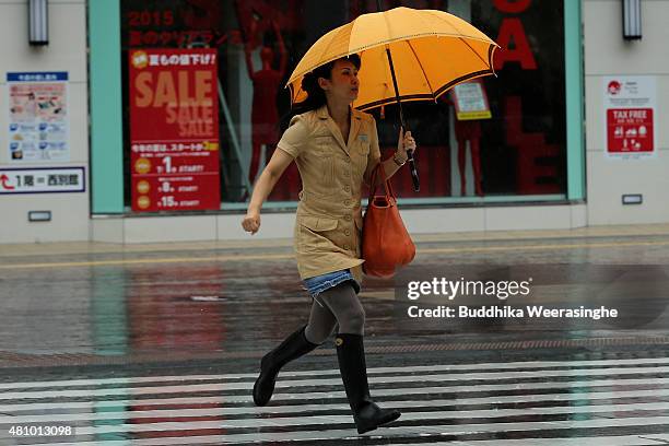 Woman runs as cross the road to escape from strong wind and rain delivered by typhoon Nangka on July 17, 2015 in Himeji, Japan. As Typhoon Nangka...