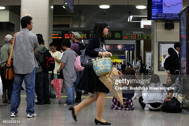 Passengers wait at the JR Station during the suspension of trains due to heavy wind and rain delivered by typhoon Nangka on July 17, 2015 in Himeji,...