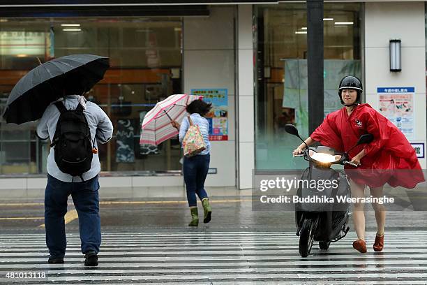 Woman pushes her bike as cross the road during the strong wind and rain delivered by typhoon Nangka on July 17, 2015 in Himeji, Japan. As Typhoon...