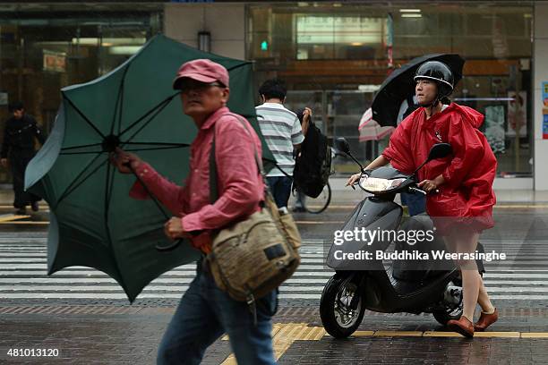 Woman pushes her bike as cross the road during the strong wind and rain delivered by typhoon Nangka on July 17, 2015 in Himeji, Japan. As Typhoon...