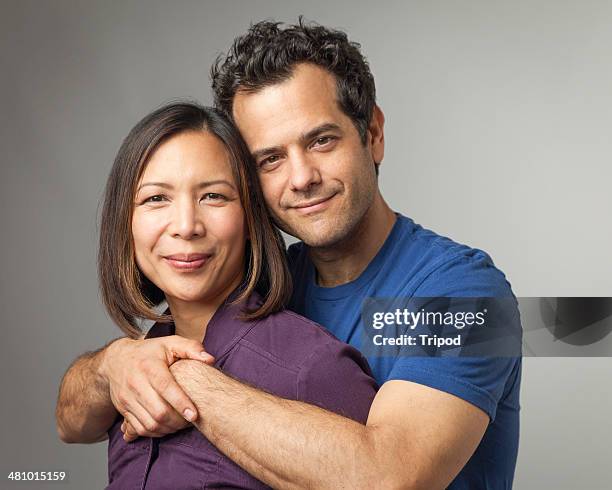 man hugging woman from behind, portrait - couples studio portrait stock-fotos und bilder