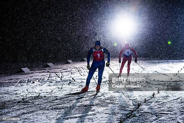 biathlon athletes skiing - night skiing stock pictures, royalty-free photos & images