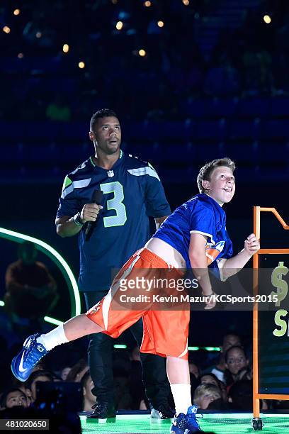Host Russell Wilson and DJ Pokoj play a football game onstage at the Nickelodeon Kids' Choice Sports Awards 2015 at UCLA's Pauley Pavilion on July...