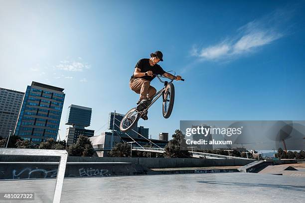 bmx fahrer springen in urbaner umgebung - bmx stock-fotos und bilder