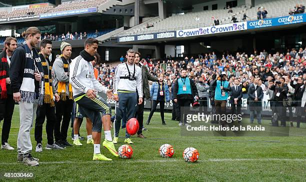 Richmond Tigers player Trent Cotchin shows Cristiano Ronaldo of Real Madrid how to kick an Australian Rules football during a Real Madrid training...