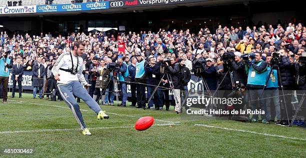 Gareth Bale of Real Madrid kicks an Australian Rules football during a Real Madrid training session at Melbourne Cricket Ground on July 17, 2015 in...