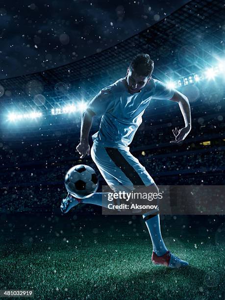 soccer player tackling a ball on stadium - foot kicking stock pictures, royalty-free photos & images
