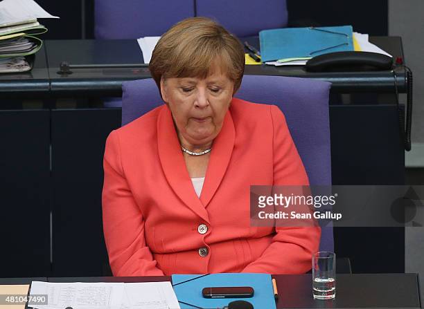 German Chancellor Angela Merkel yawns as she attends debates prior to a vote over the third EU financial aid package to Greece at an extraordinary...