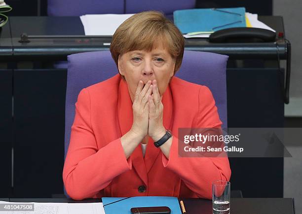 German Chancellor Angela Merkel yawns as she attends debates prior to a vote over the third EU financial aid package to Greece at an extraordinary...