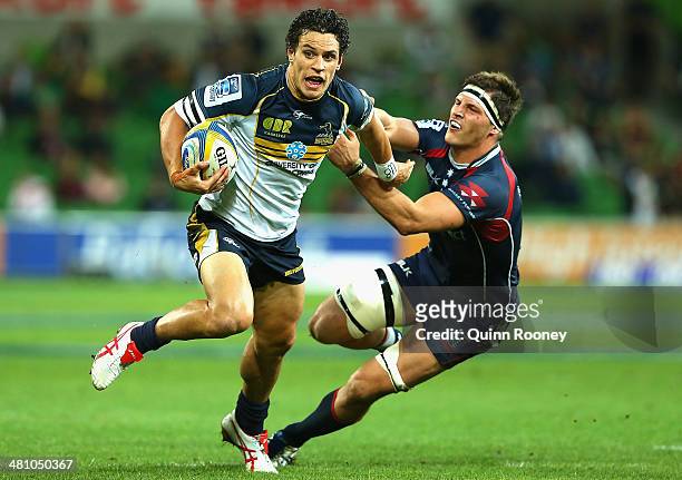 Matt Toomua of the Brumbies fends off a tackle during the round seven Super Rugby match between the Rebels and the Brumbies at AAMI Park on March 28,...
