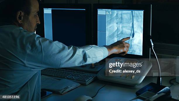 doctor monitoring injection process into blood vessels - cardiovascular system stockfoto's en -beelden