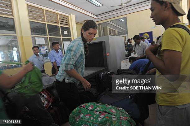 Non-Govermental Organizations staff check in at an airline counter at Sittwe airport, Rakhine state western Myanmar on March 28, 2014. An 11-year-old...