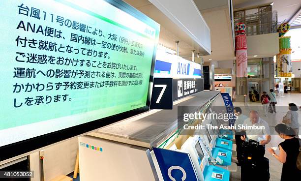 Screen displaying the flight cancellation notice due to the Typhoon Nangka is seen at the check in counter of the Osaka Airport on July 17, 2015 in...