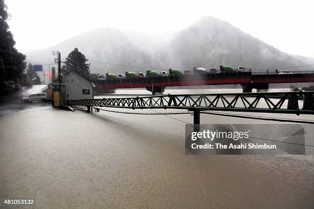 Cement mixer trucks are evacuated on a bridge as a concrete company premises are flooded due to the heavy rain triggered by Thphoon Nangka on July...