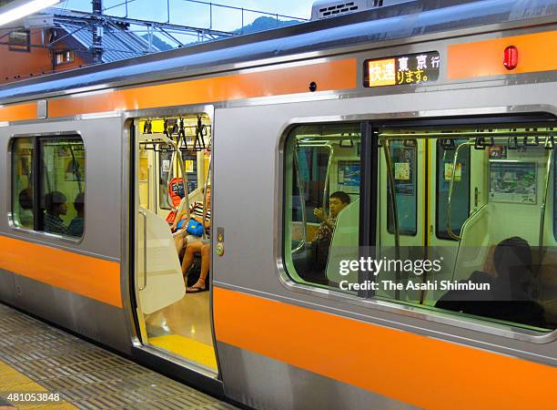 People stay a night on the train as the service suspended as the Typhoon Nangka approaching on July 16, 2015 in Hachioji, Tokyo, Japan. The typhoon...