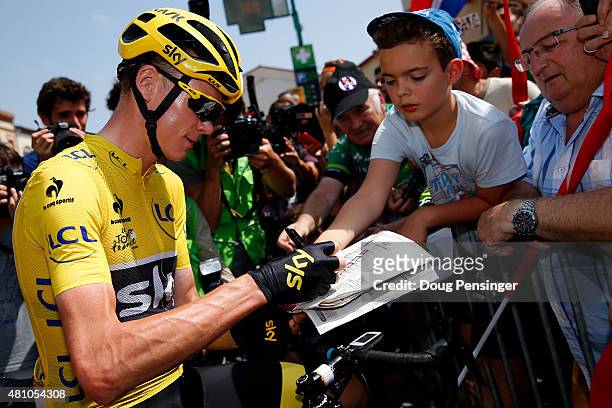 Chris Froome of Great Britain and Team Sky signs autographs for fans before the start of stage thirteen of the 2015 Tour de France, a 198.5 km stage...