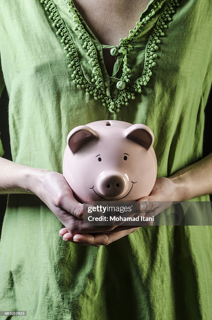 Woman holding a pink piggy bank
