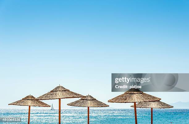 la mer et parasols sur la plage - sailing greece photos et images de collection