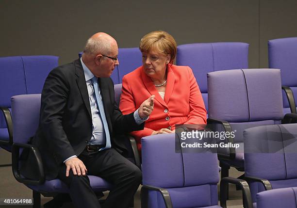 German Chancellor Angela Merkel and Christian Democrats Bundestag faction leader Volker Kauder speak with one another during debates prior to votes...