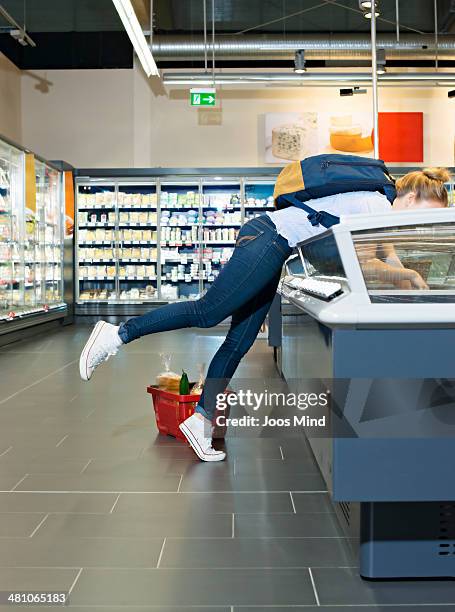 young woman reaching for diary produce in supermar - frozen food supermarket stock pictures, royalty-free photos & images