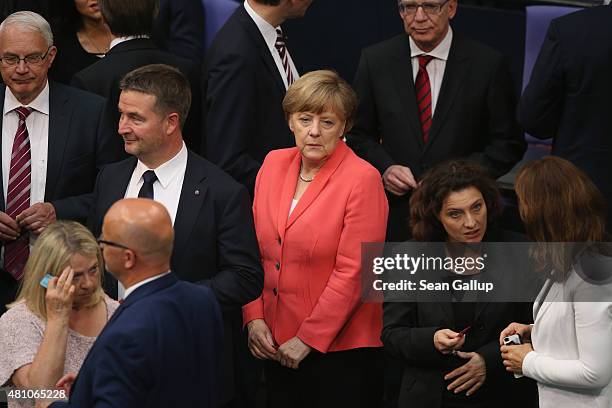German Chancellor Angela Merkel waits to cast her ballot during votes over the third EU financial aid package to Greece at an extraordinary session...