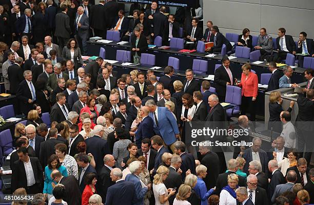 Parliamentarians, including German Chancellor Angela Merkel cast their ballots during votes over the third EU financial aid package to Greece at an...