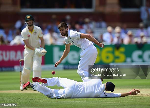 Mark Wood and Joe Root of England field the ball during day two of the 2nd Investec Ashes Test match between England and Australia at Lord's Cricket...