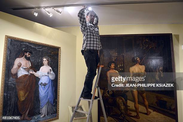 Employees prepare the exhibtion "Du romantisme à l'impressionisme" dedicated to the paintings by French artist Alfred Bellet du Poisat at the...