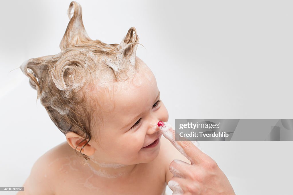 Baby boy in bath and mother's hand