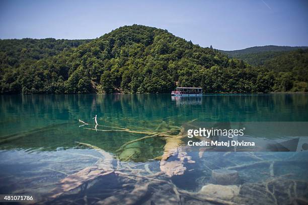 Boat crosses Kozjak lake at Plitvice Lakes National Park on July 6, 2015 near Plitvicka Jezera, Croatia. Plitvice Lakes National Park is Croatia's...