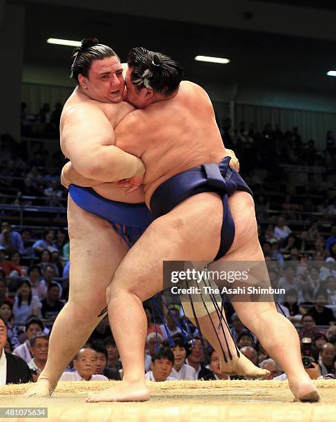 Mongolian yokozuna Kakuryu pushes Bulgarian wrestler Aoiyama out of the ring to win during day six of the Grand Sumo Nagoya Tournament at Aichi...