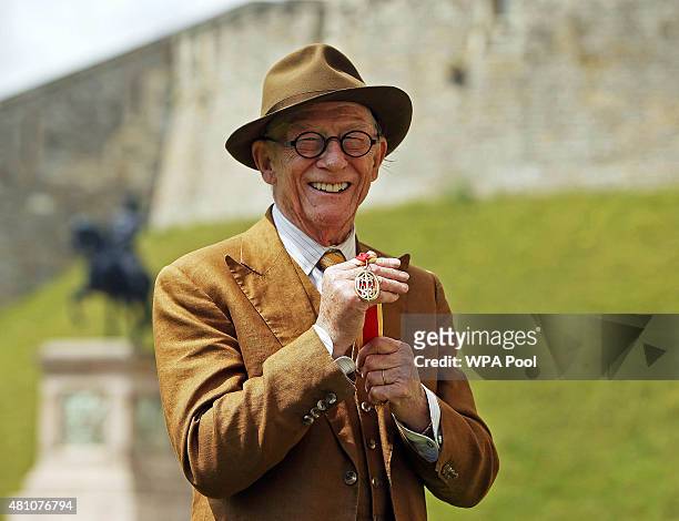 British actor Sir John Hurt poses after being awarded a knighthood by Queen Elizabeth II during an Investiture ceremony at Windsor Castle on July 17,...