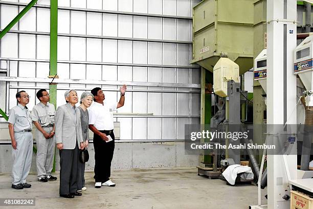 Emperor Akihito and Empress Michiko listen to an explanation of a grain drying machine at a farm ahead of visiting the Nasu Imperial Villa on July...