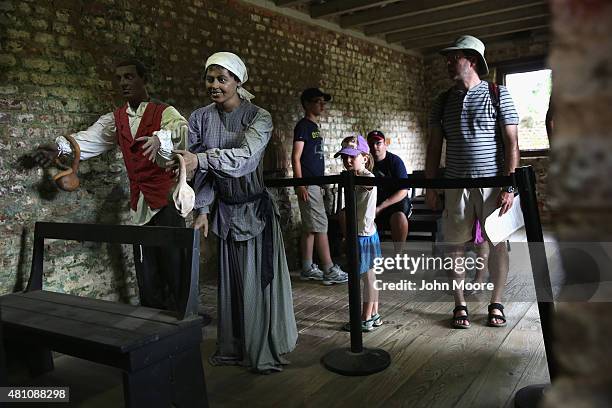 Tourists look over mannequins in the former slave quarters of the Boone Hill Plantation on July 16, 2015 in Mount Pleasant, South Carolina. The...
