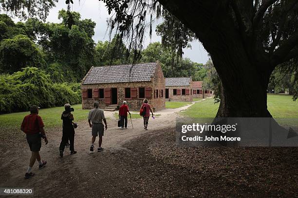 Tourists walk past the former slave quarters of the Boone Hill Plantation on July 16, 2015 in Mount Pleasant, South Carolina. The plantation, founded...