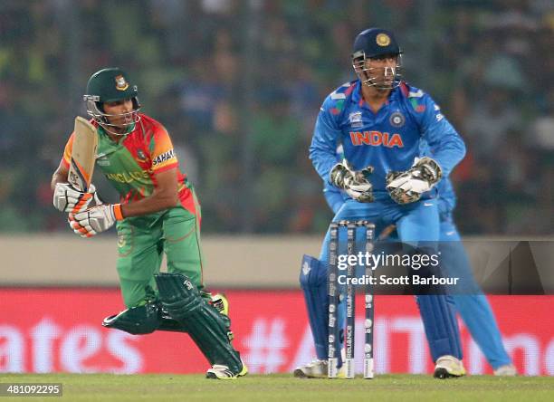 Anamul Haque of Bangladesh bats as MS Dhoni of India looks on during the ICC World Twenty20 Bangladesh 2014 match between Bangladesh and India at...