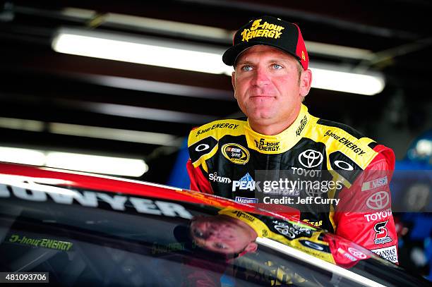 Clint Bowyer, driver of the 5-Hour Energy Toyota, stands in the garage area during practice for the NASCAR Sprint Cup Series 5-Hour Energy 301 at New...