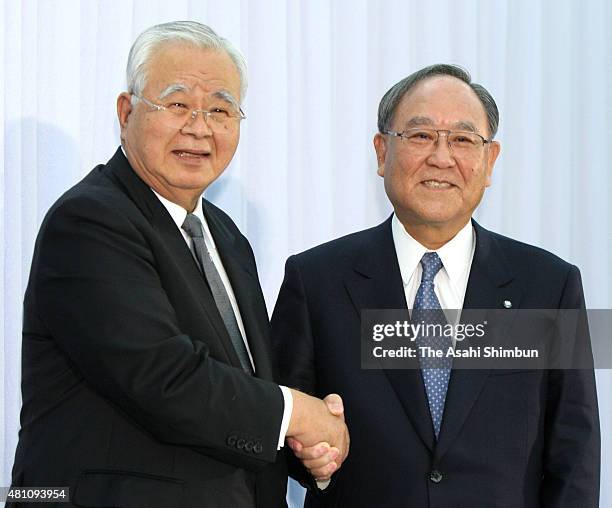 Incoming Keidanren, Japan Business Federation President Hiromasa Yonekura and outgoing president Fujio Mitarai shake hands during a press conference...
