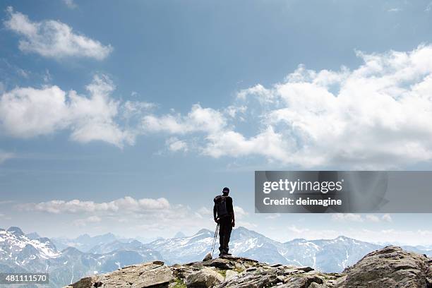 hiker on top of mountain - person standing far stockfoto's en -beelden