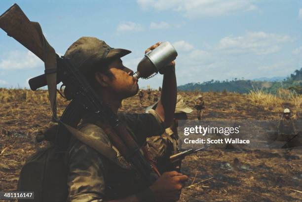 Soldier of the Sandinista Popular Army drinking from a water bottle, Nicaragua, 1985.