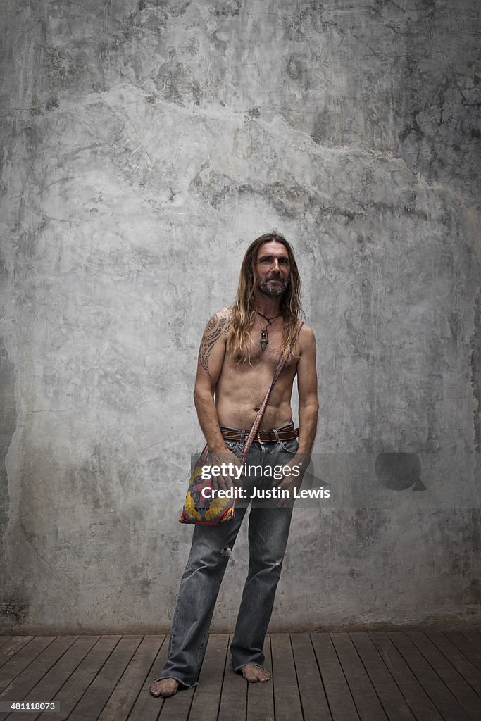 Male wearing a colorful shoulder bag on blank wall